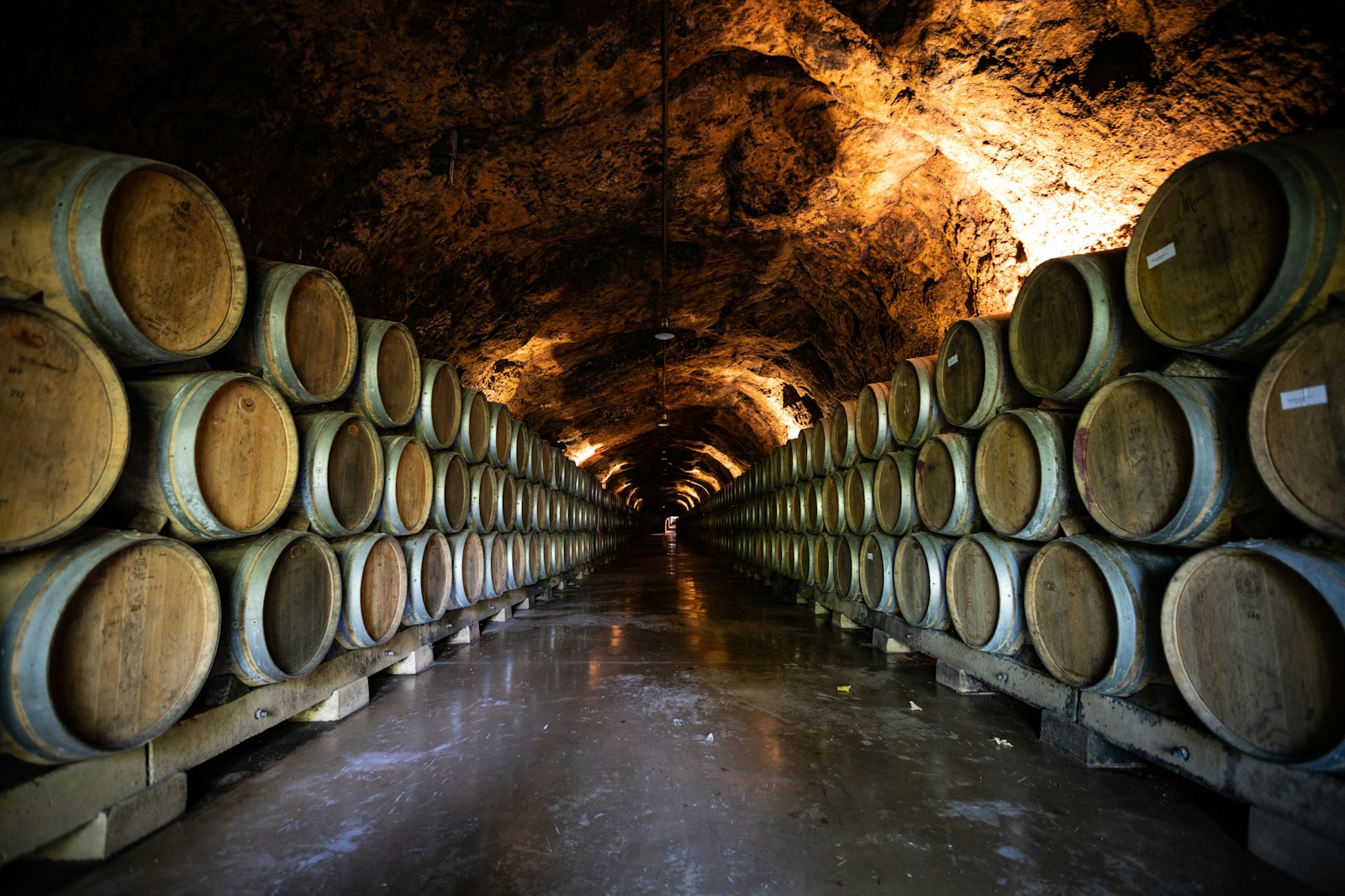 Oak barrels stacked three high in a rock-cut ageing cave